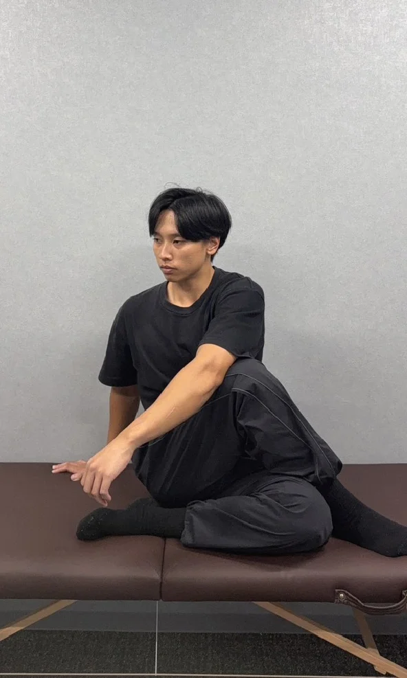 腰ストレッチ前の状態。体を回旋して後方を見れない男性。